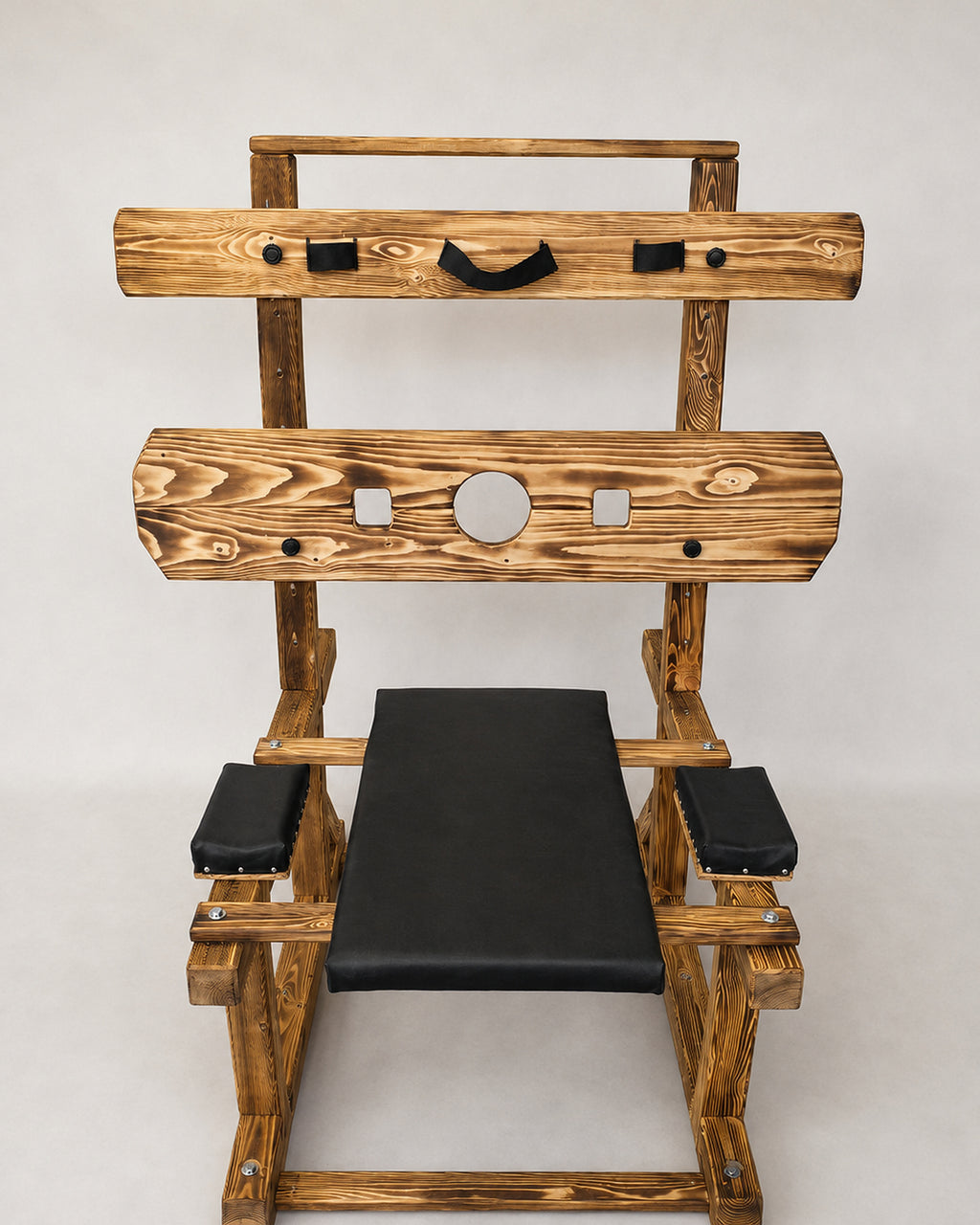 Front view of wooden pillory bench with padded supports