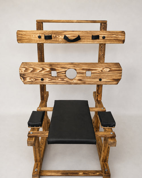 Front view of wooden pillory bench with padded supports