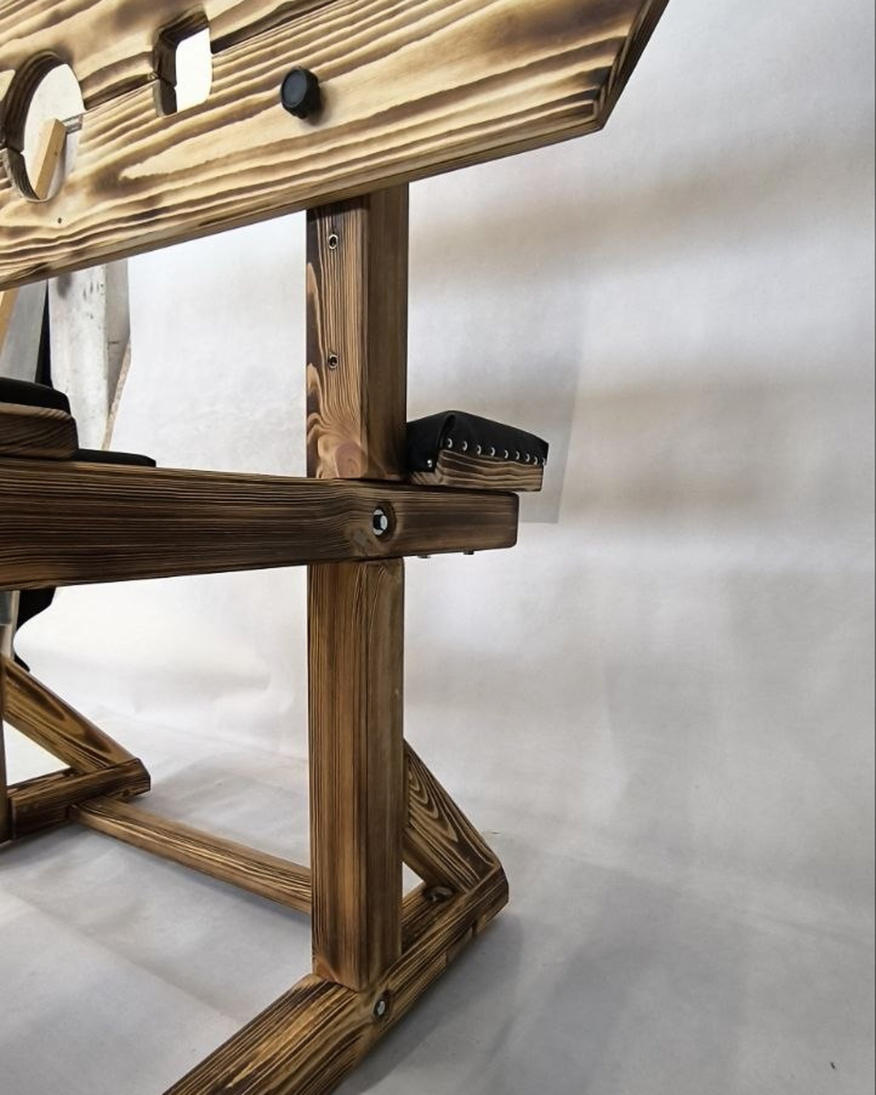 Side view of wooden pillory bench showing the wooden frame